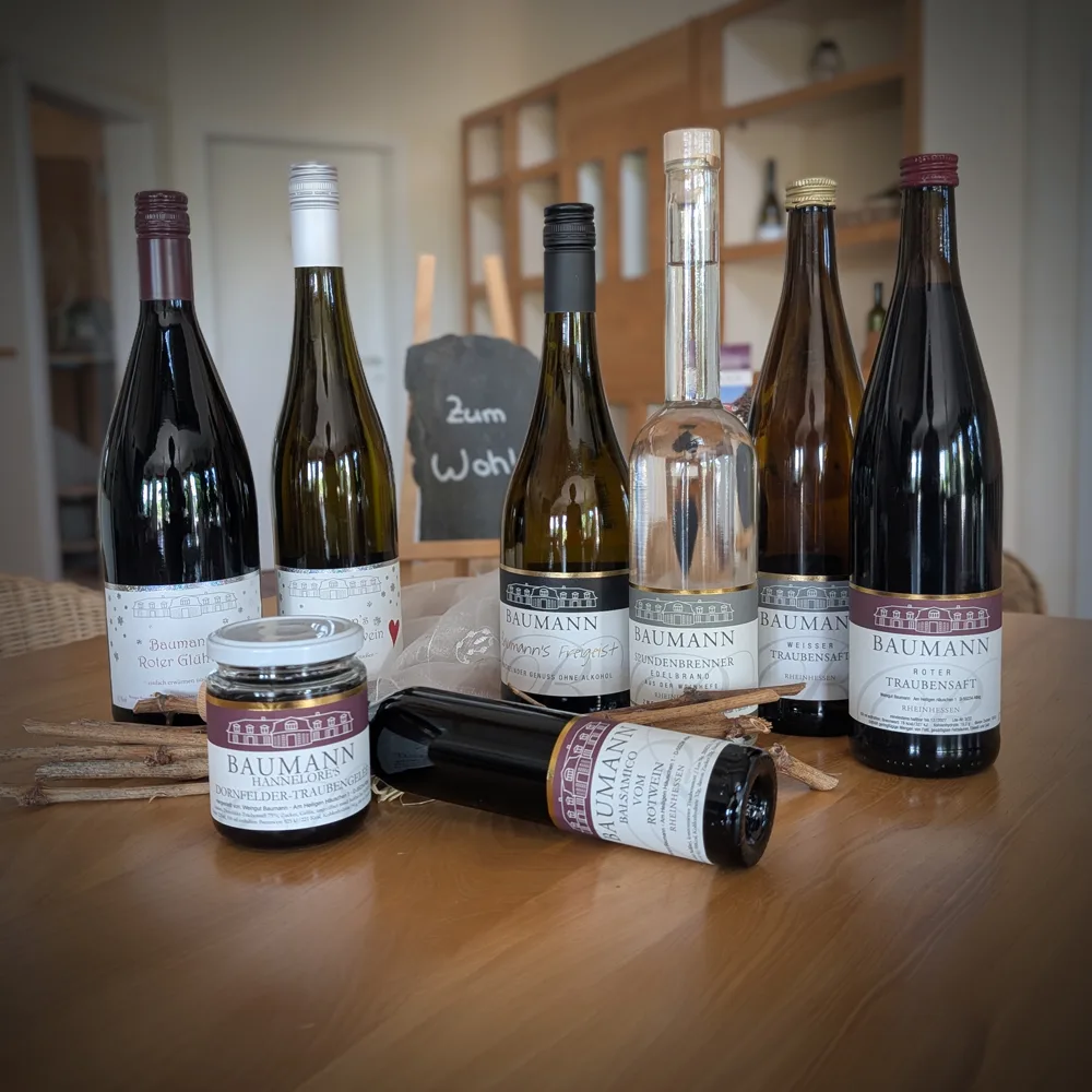 Spezialitäten vom Weingut Baumann: Flaschen und ein Glas Gelee auf einem Holztisch